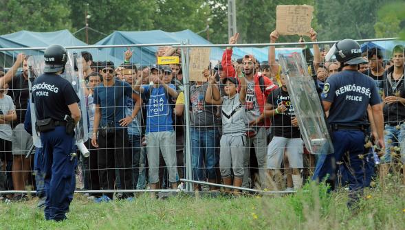 
Des réfugiés gardés par des policiers hongrois dans un camp proche de Roszke à la frontière serbe. photo AFP

AFP
