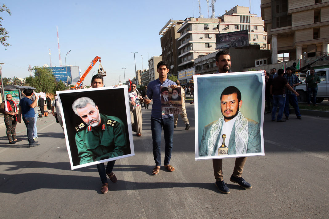 Le portrait du général Soleimani est brandi lors d’une manifestation, en mars 2015 à Bagdad, contre l’intervention militaire au Yémen de la coalition menée par l’Arabie saoudite. A droite, la photo du leader des rebelles houtistes,  Abdel Malik Al-Houthi.